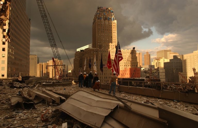 Rescue workers and clean up crews pictures with American flag at ground zero. Image by WikiImages from Pixabay