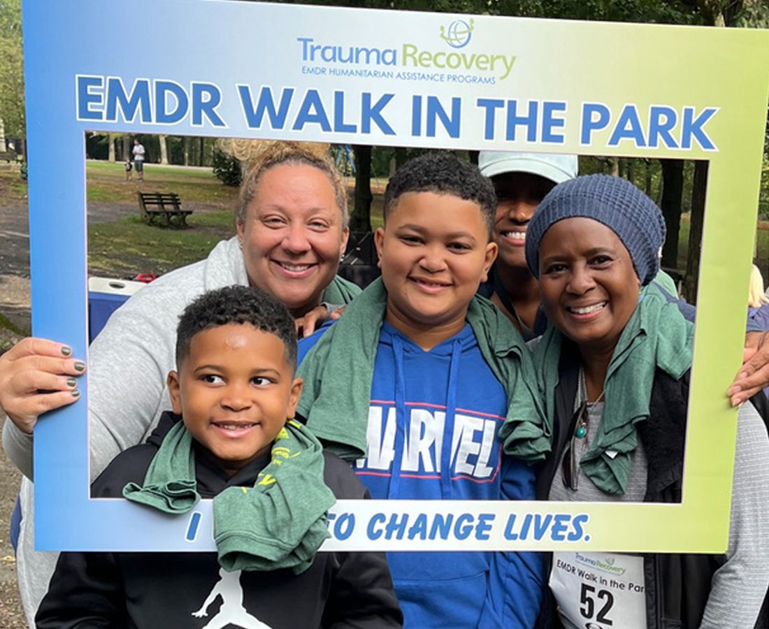 A multi-generational family posing with an EMDR Walk in the Park sign