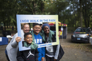 Group of walkers poses with cutout sign that says I walk to save lives.
